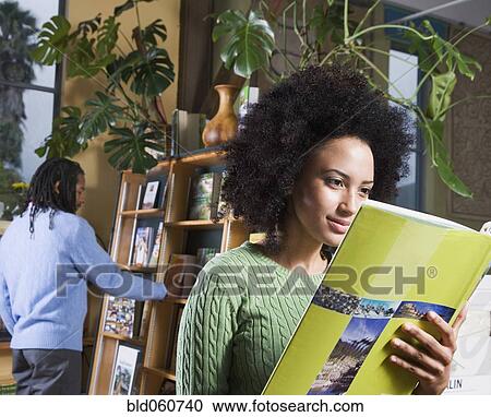 Stock Image - African woman reading book. Fotosearch
