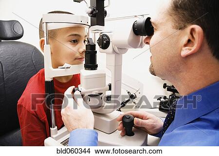 Picture - Asian boy having eyes examined. Fotosearch