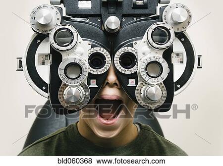 Stock Photo - Asian boy having eyes examined. Fotosearch