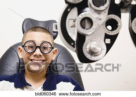 Stock Photograph - Asian boy in eye doctor’s office. Fotosearch