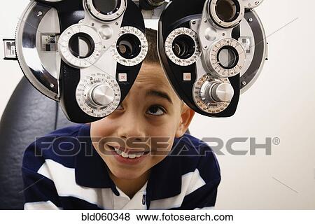Asian boy looking at eye examination equipment View Large Photo Image Stock Photo - Asian boy looking at eye examination equipment. Fotosearch