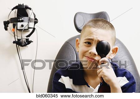 Stock Photography - Asian boy taking eye exam. Fotosearch