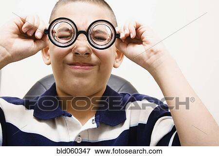 Asian boy taking off eye glasses View Large Photo Image Stock Photo - Asian boy taking off eye glasses. Fotosearch
