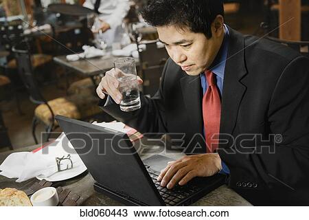 Stock Image - Asian businessman typing on laptop. Fotosearch