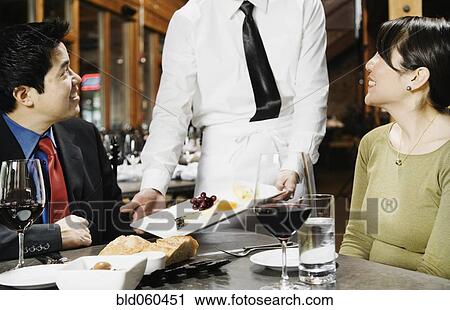 Stock Image - Asian couple eating at restaurant. Fotosearch