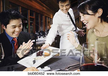 Stock Image - Asian couple eating at restaurant. Fotosearch