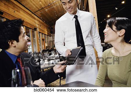Asian couple paying restaurant bill View Large Photo Image Picture - Asian couple paying restaurant bill. Fotosearch