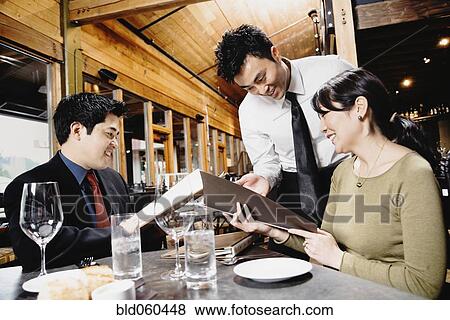 Asian couple reading menu at restaurant View Large Photo Image Stock Photo - Asian couple reading menu at restaurant. Fotosearch