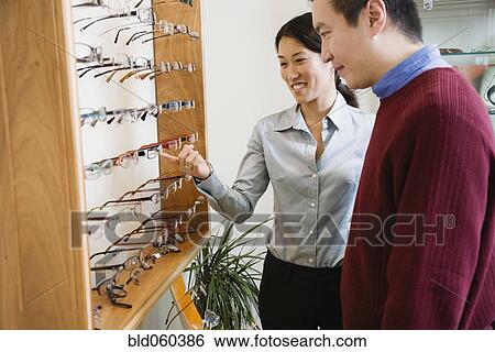 Stock Photograph - Asian couple shopping for eyeglasses. Fotosearch