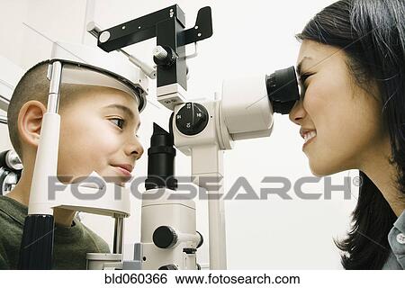 Asian female optometrist examining patient View Large Photo Image Stock Photograph - Asian female optometrist examining patient. Fotosearch