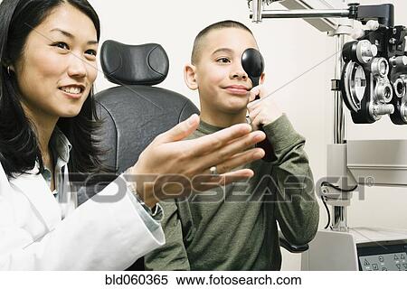 Asian female optometrist examining patient View Large Photo Image Stock Photography - Asian female optometrist examining patient. Fotosearch