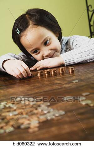Stock Image - Asian girl counting coins. Fotosearch