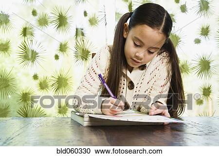 Stock Image - Asian girl doing homework. Fotosearch