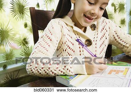 Stock Image - Asian girl doing homework. Fotosearch