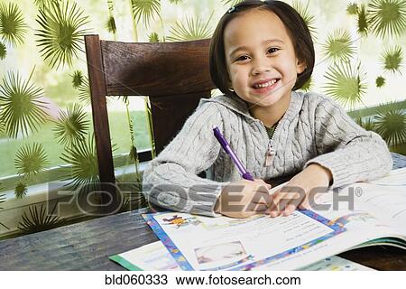 Stock Image - Asian girl doing homework. Fotosearch