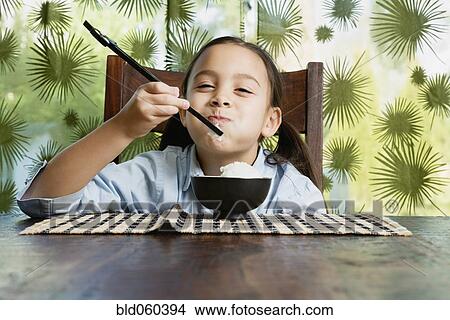 Asian girl eating bowl of rice View Large Photo Image Picture - Asian girl eating bowl of rice. Fotosearch