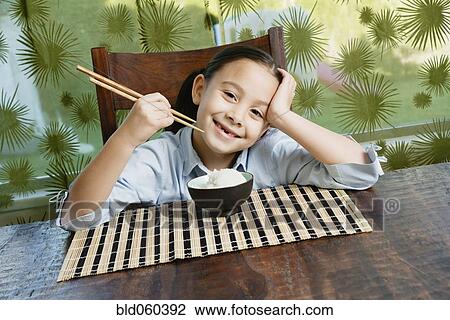 Asian girl eating bowl of rice View Large Photo Image Stock Image - Asian girl eating bowl of rice. Fotosearch