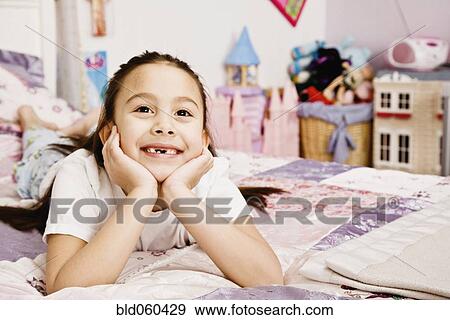 Asian girl laying on bed View Large Photo Image Stock Photo - Asian girl laying on bed. Fotosearch