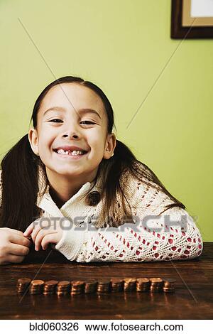 Asian girl next to stacked coins View Large Photo Image Stock Photograph - Asian girl next to stacked coins. Fotosearch