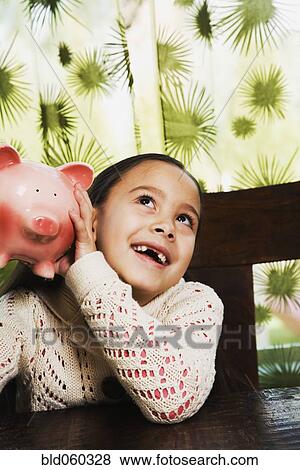 Stock Photo - Asian girl shaking piggy bank. Fotosearch