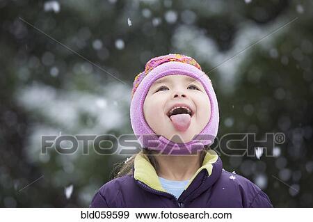 Asian girl sticking out tongue in snow View Large Photo Image Stock Photo - Asian girl sticking out tongue in snow. Fotosearch