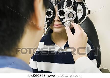 Asian male optometrist examining patient View Large Photo Image Stock Image - Asian male optometrist examining patient. Fotosearch