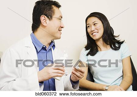 Asian male optometrist giving contact lenses to patient View Large Photo Image Stock Image - Asian male optometrist giving contact lenses to patient. Fotosearch