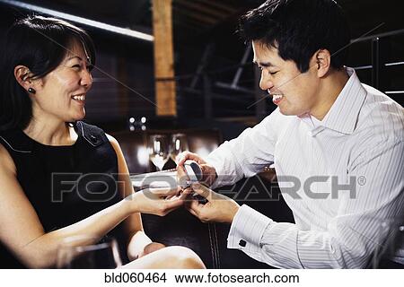 Picture - Asian man proposing to girlfriend. Fotosearch