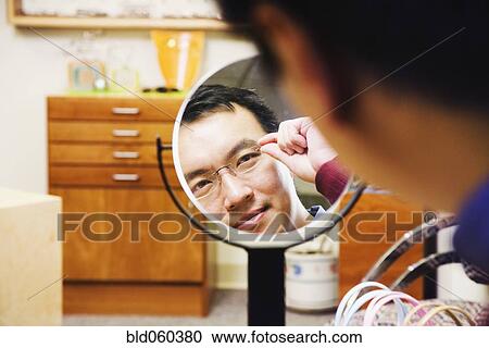 Asian man trying on eyeglasses View Large Photo Image Stock Image - Asian man trying on eyeglasses. Fotosearch