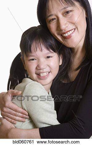 Stock Image - Asian mother and daughter hugging. Fotosearch
