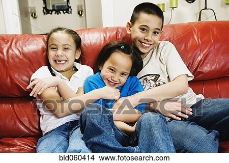 Picture - Asian siblings tickling sister. Fotosearch
