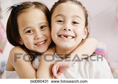 Stock Image - Asian sisters hugging. Fotosearch
