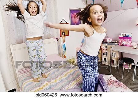 Asian sisters jumping on bed View Large Photo Image Stock Photograph - Asian sisters jumping on bed. Fotosearch
