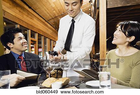 Asian waiter pouring wine for customers View Large Photo Image Stock Photo - Asian waiter pouring wine for customers. Fotosearch