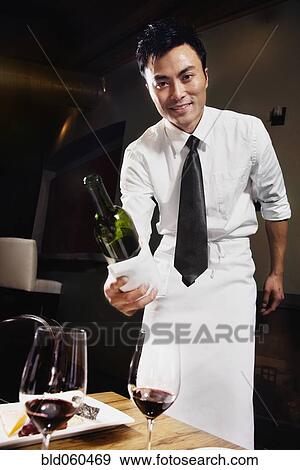 Asian waiter pouring wine View Large Photo Image Stock Photo - Asian waiter pouring wine. Fotosearch