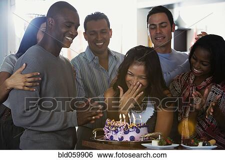 Stock Photograph - Asian woman celebrating birthday with multi-ethnic friends. Fotosearch