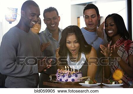 Stock Photography - Asian woman celebrating birthday with multi-ethnic friends. Fotosearch