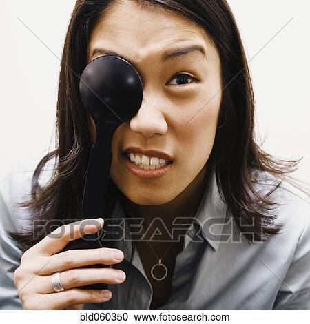 Stock Image - Asian woman covering eye. Fotosearch