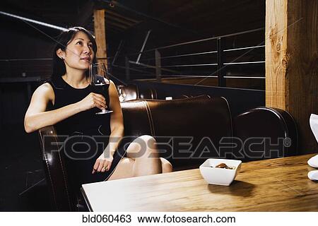 Stock Image - Asian woman drinking wine. Fotosearch