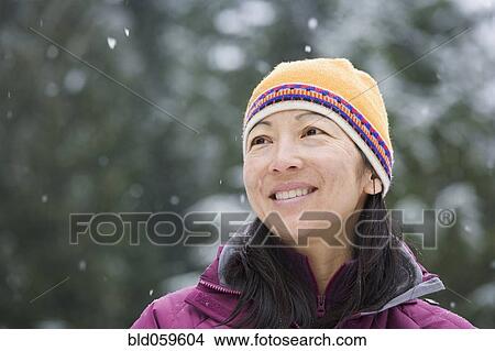 Picture - Asian woman wearing hat in snow. Fotosearch