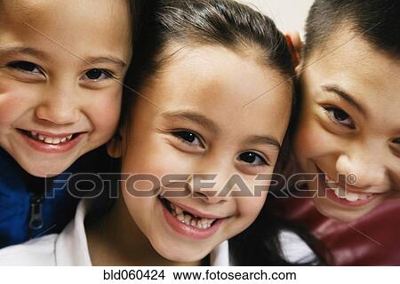 Picture - Close up of Asian siblings smiling. Fotosearch