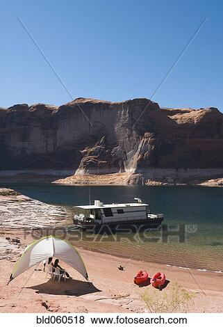 Stock Photo - Friends sitting under tent next to houseboat. Fotosearch