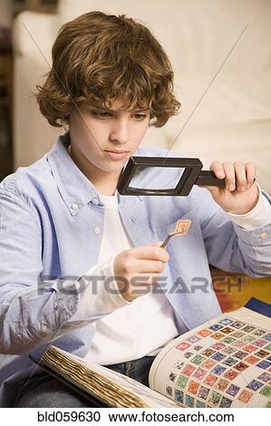 Hispanic boy examining stamp through magnifying glass View Large Photo Image Stock Image - Hispanic boy examining stamp through magnifying glass. Fotosearch