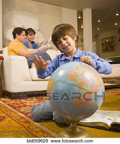 Stock Photo - Hispanic boy spinning globe. Fotosearch