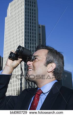 Hispanic businessman looking through binoculars View Large Photo Image Stock Photo - Hispanic businessman looking through binoculars. Fotosearch