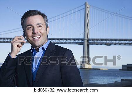 Stock Image - Hispanic businessman talking on cell phone. Fotosearch