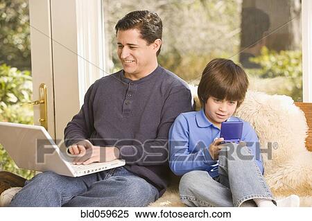 Hispanic father and son relaxing View Large Photo Image Stock Photography - Hispanic father and son relaxing. Fotosearch