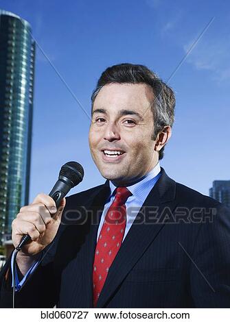 Hispanic male reporter holding microphone View Large Photo Image Stock Photo - Hispanic male reporter holding microphone. Fotosearch