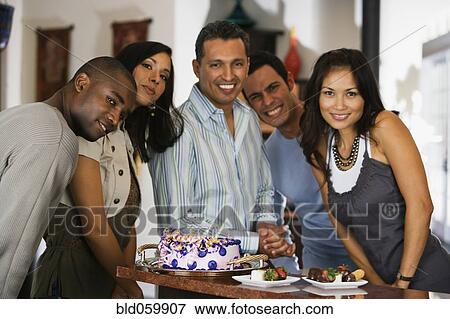 Stock Photo - Hispanic man celebrating birthday with multi-ethnic friends. Fotosearch