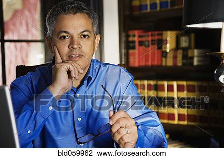 Hispanic man holding eyeglasses View Large Photo Image Stock Image - Hispanic man holding eyeglasses. Fotosearch
